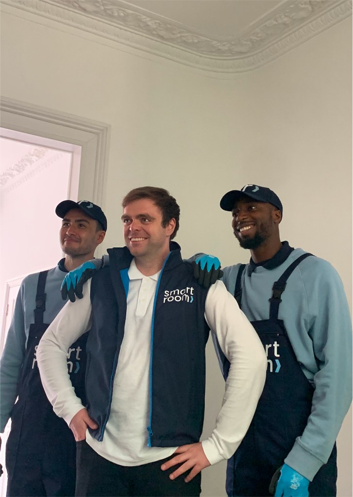 Three professional movers from Smartroom working together to pack and transport items for self storage in London.