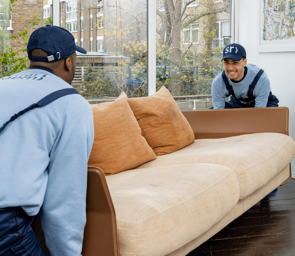 Professional movers lifting a sofa into a moving van for self storage at Smartroom in London.